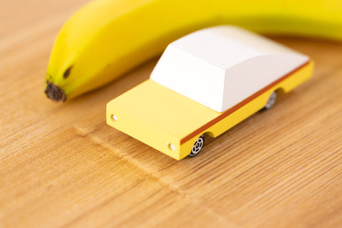 Gul liten träbil och en banan