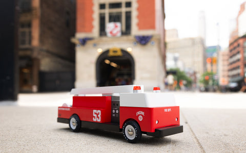 Leksaksbrandbil med stege utanför brandkåren i New York. Candylab Toys - Engine 53